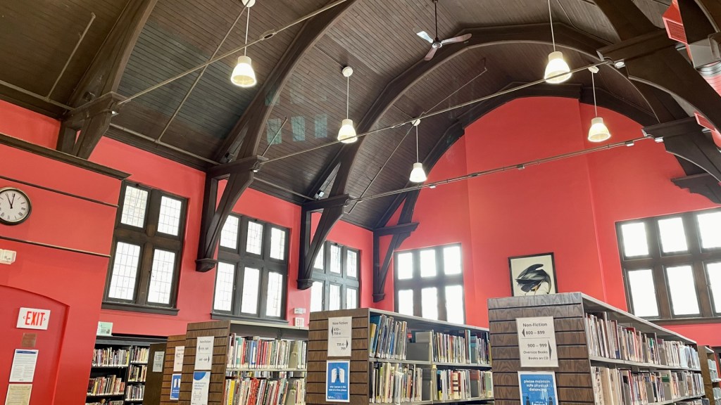public library with red walls and dark brown vaulted wooden ceiling